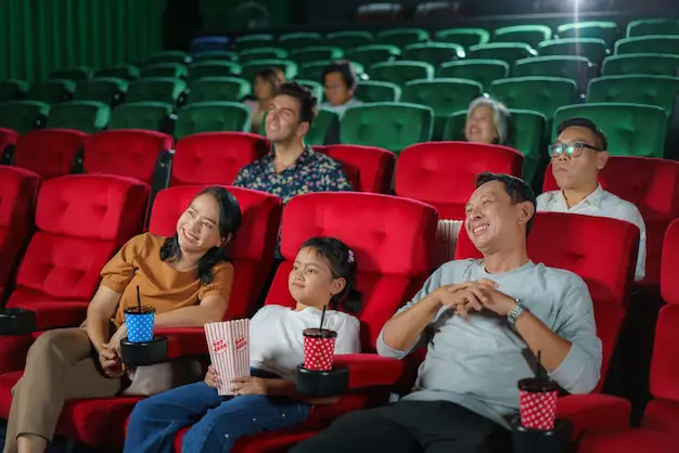 Keluarga bahagia sedang menonton film di bioskop
